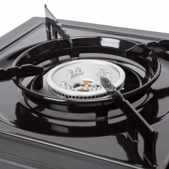 Close-up of a black gas stove burner with visible flame on a white background