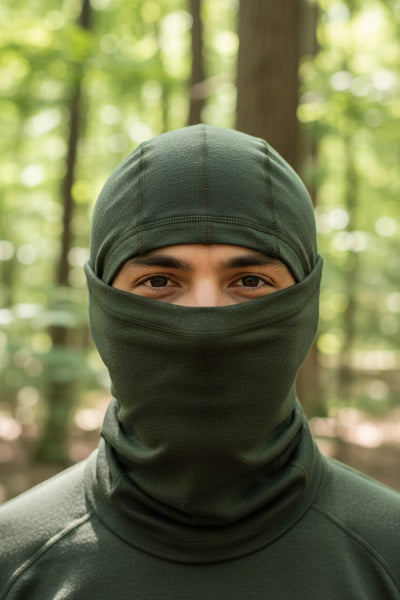 Person wearing a green balaclava in a forest setting