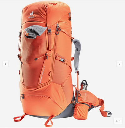 An orange Deuter hiking backpack shown on a light gray background, with a matching orange hydration bottle and a gray neck gaiter.