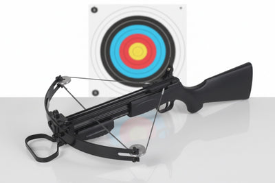 Black crossbow with a target in the background on a white surface