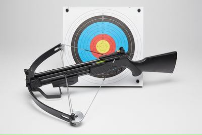 Crossbow with arrow on a target practice board against a white background