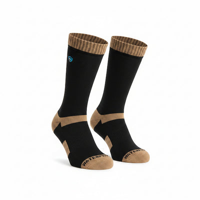 A pair of crew socks in black with tan accents on the heel, toe, and ribbed cuff, featuring a small blue circular logo on one sock.