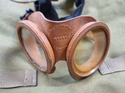 Vintage copper goggles with engraving on a green fabric background