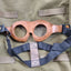 Brown goggles with blue straps on a green fabric background