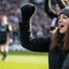Person celebrating on a sports field with a crowd in the background