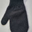 Dark gray knitted mitten on a light gray background