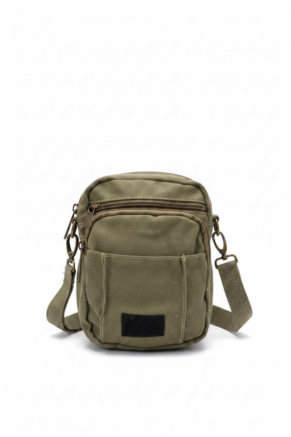 Green tactical pouch hanging on a surface with a blurred background