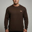 Man wearing a brown sweater with a small logo on a gray background
