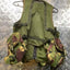 Green tactical vest with camouflage pouches on a metallic surface