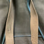 Beige strap on a gray bag with a blue handle