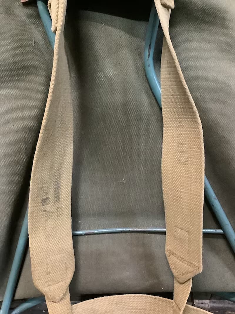 Beige strap on a gray bag with a blue handle