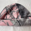 Pink and gray patterned fleece blanket on a white surface