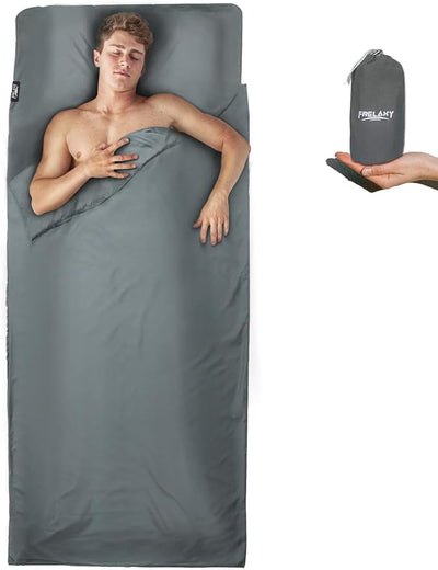 Person lying on a gray sleeping bag with a carrying case displayed.