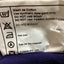 Clothing label with care instructions on a purple fabric background