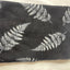 Folded towel with fern leaf pattern on a light background