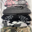 Stack of camouflage-patterned beanies on a white background