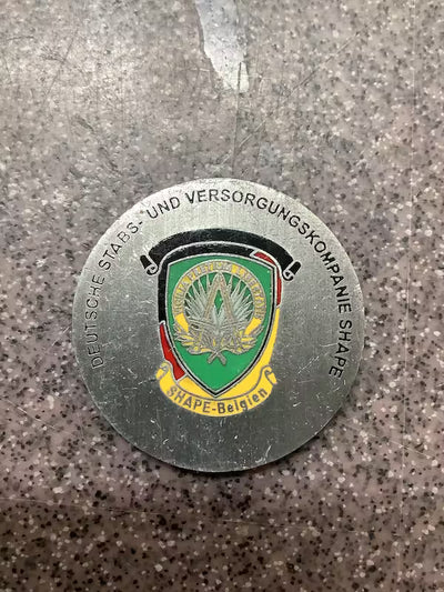 Metallic badge with emblem and text on a textured surface