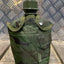 Green camouflage canteen on a metal and wooden surface