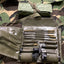 Set of tools in a green case on camouflage fabric