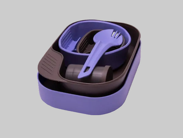 Set of purple and gray utensils in a container on a light gray background