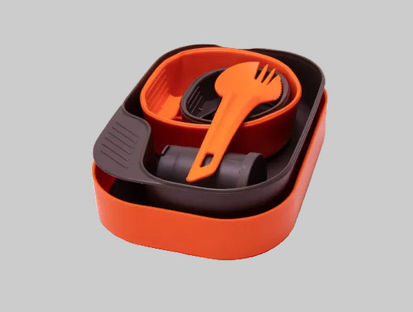 Orange and black camping cookware set on a gray background