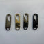 Four metal carabiners in different colors on a white background