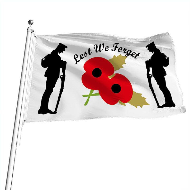 Flag with silhouettes of soldiers, red poppies, and 'Lest We Forget' text on a white background