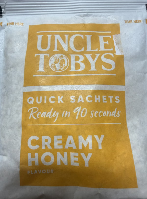 Uncle Toby's creamy honey quick sachet on a white background