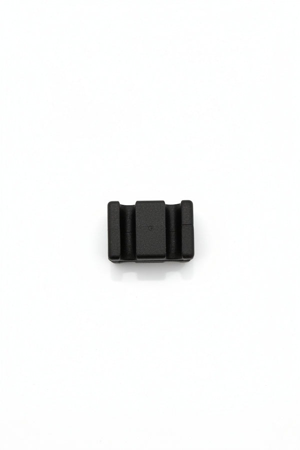 A small black plastic component or connector piece shown from above on a plain white background.