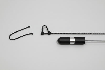 Black and silver cylindrical device with a rope on a gray background