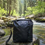 Black bag on a rock by a stream in a forest