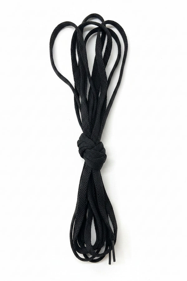 Black shoelaces tied into a knot on a white background
