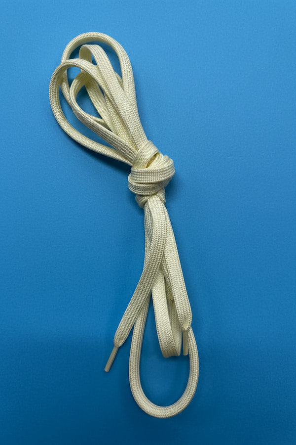 Beige shoelace tied in a knot on a blue background