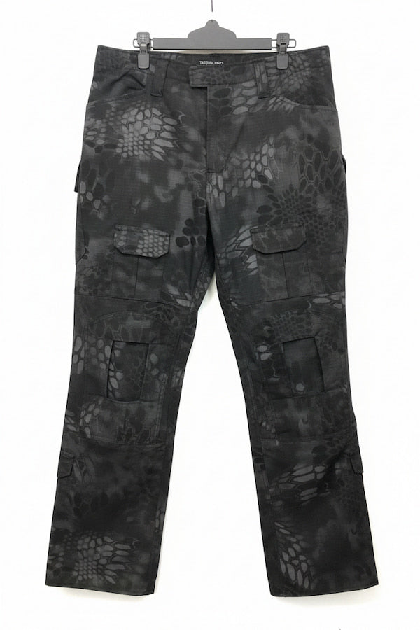 Black and gray camouflage cargo pants with a reptile-scale pattern, hanging on a black hanger against a white background.