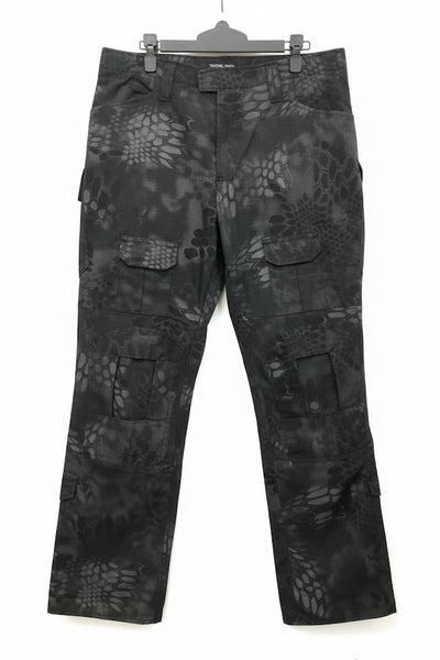 Black and gray camouflage cargo pants with a reptile-scale pattern, hanging on a black hanger against a white background.