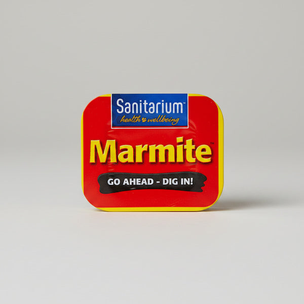 Red tin of Sanitarium Marmite on a gray background