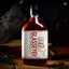 Bottle of Glasseye Creek meat sauce on a wooden surface with a dark background
