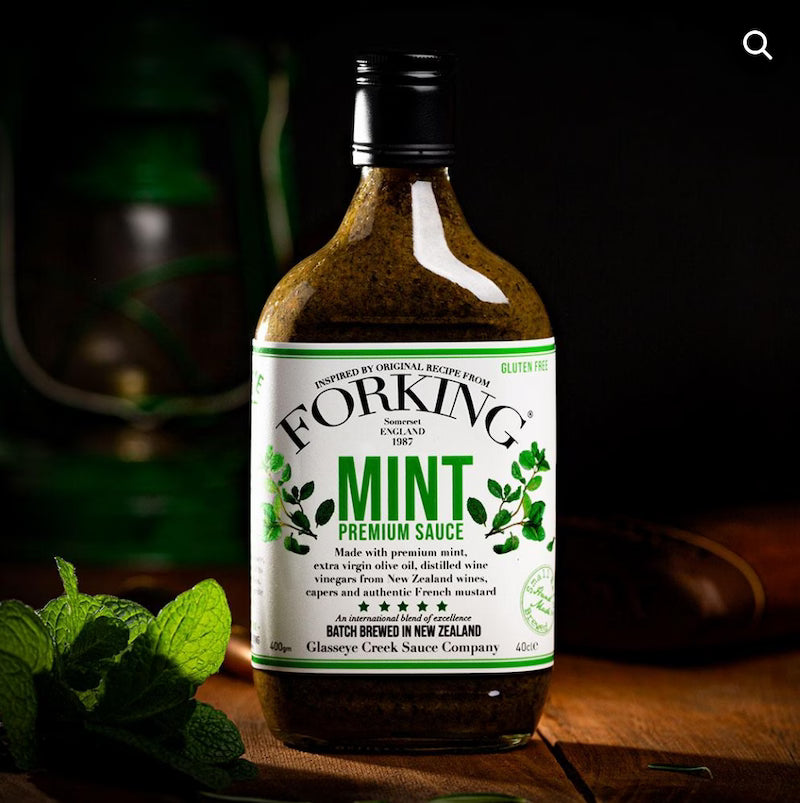 Bottle of Forking Mint Premium Sauce with a label on a wooden surface.
