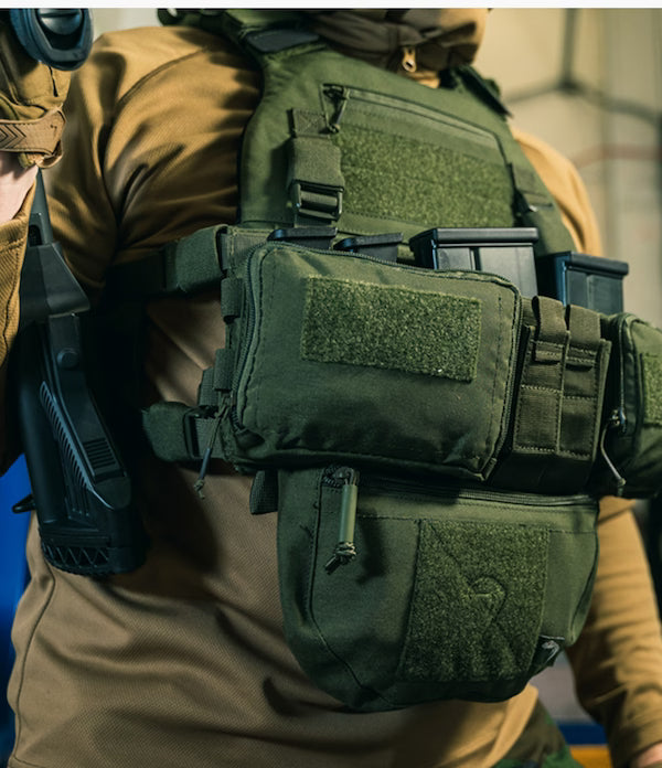 Person wearing a tactical vest with various pouches and equipment.