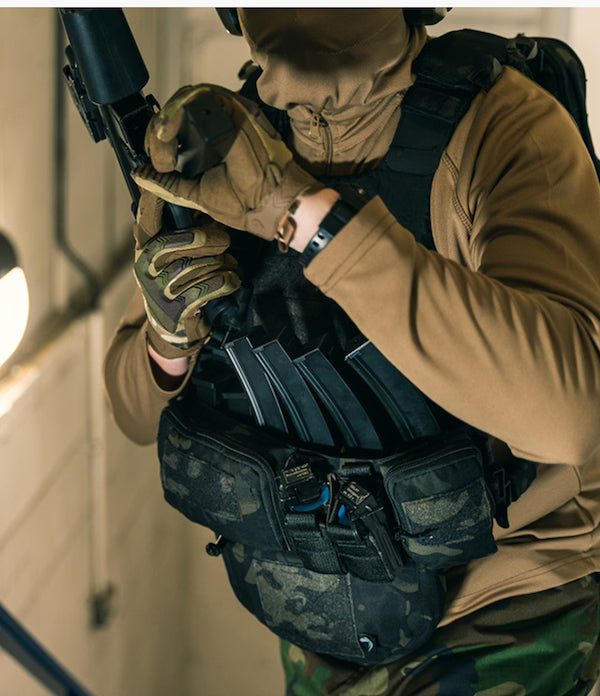 Person in tactical gear holding a weapon and magazine pouches.
