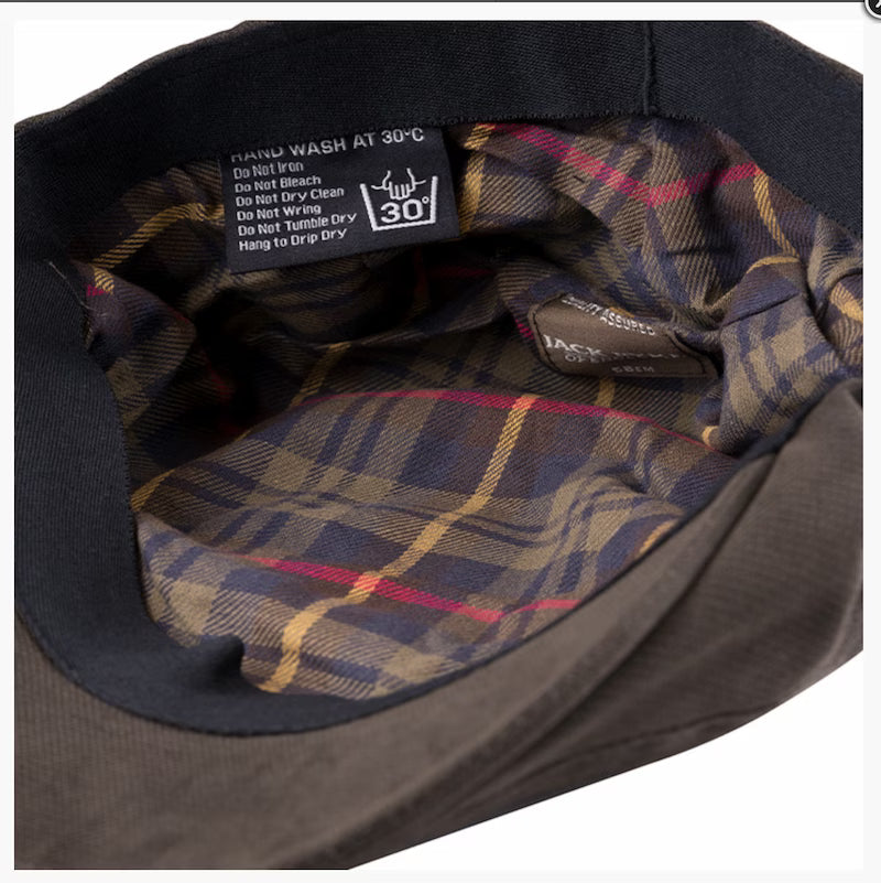 Close-up of a plaid fabric lining with care label on a dark background