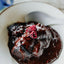Chocolate dessert with a raspberry on a white plate