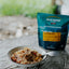 Backcountry Cuisine package with a bowl of food on a wooden surface