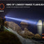Person using a flashlight on a cliffside with scenic background, highlighting ACEBEAM K75 flashlight's range.