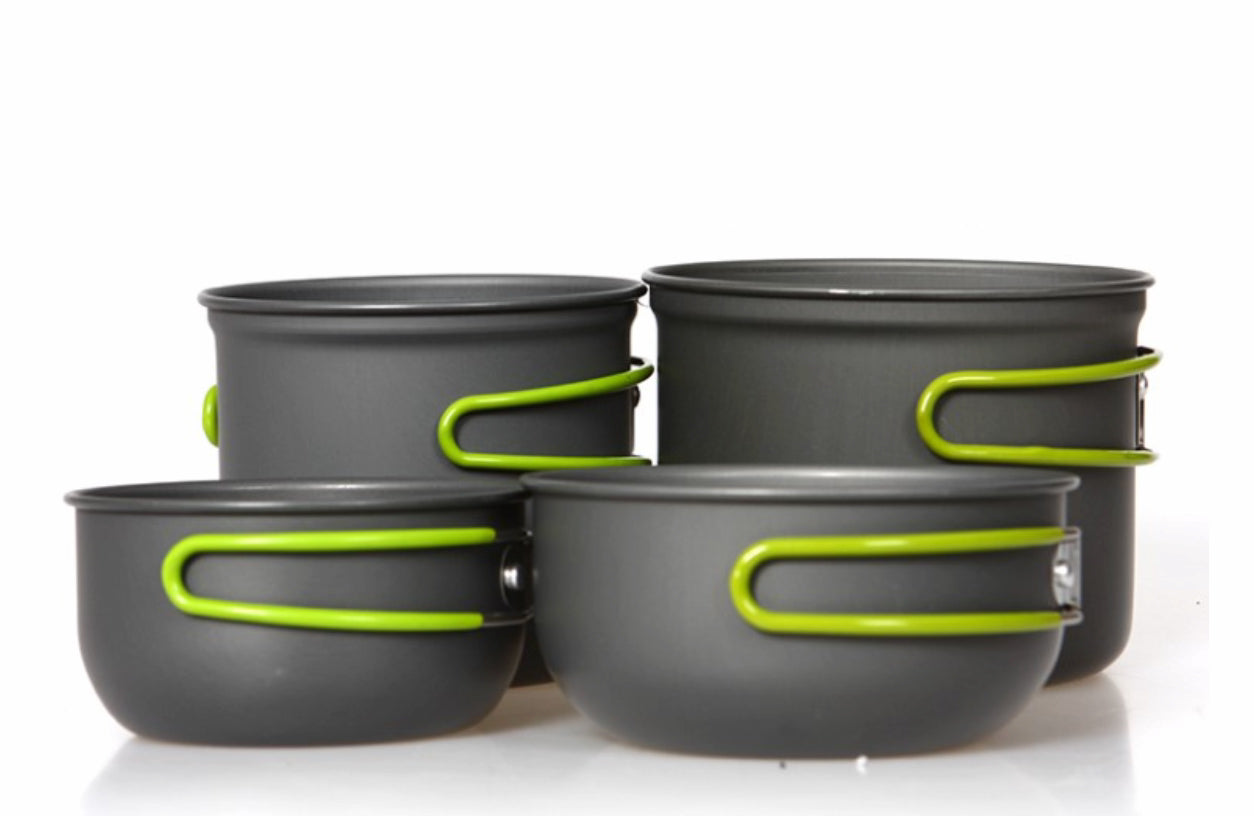 Set of gray camping pots with green handles on a white background