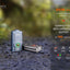 Fenix E03R v2.0 keychain flashlight on a textured surface with blurred natural background
