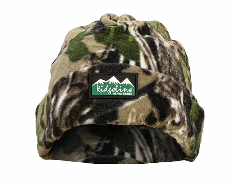 A fleece winter beanie hat in a green, brown, and black camouflage pattern, featuring a black rectangular patch on the front with a white mountain graphic and the text 'Ridgeline Outdoors of New Zealand'.