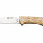 A pocket knife with a silver stainless steel blade and a textured, light tan wood handle, shown against a plain white background. The blade features the 'Cocker' brand name and logo.