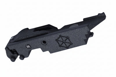 A black textured polymer or metal component, likely a firearm accessory or tool part, featuring an embossed geometric star-like logo, shown on a plain white background.