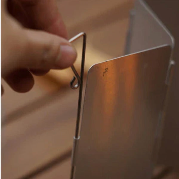Hand adjusting a metal hook on a reflective surface